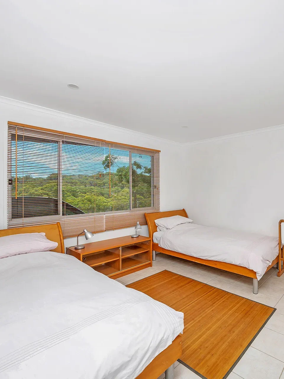 Bright bedroom with twin beds and tiled floors at Bayview