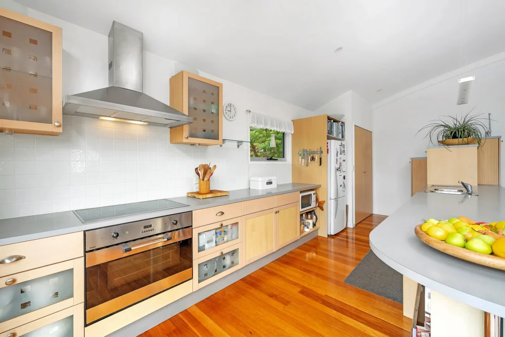 Modern kitchen with wooden cabinets and island bench at Bayview