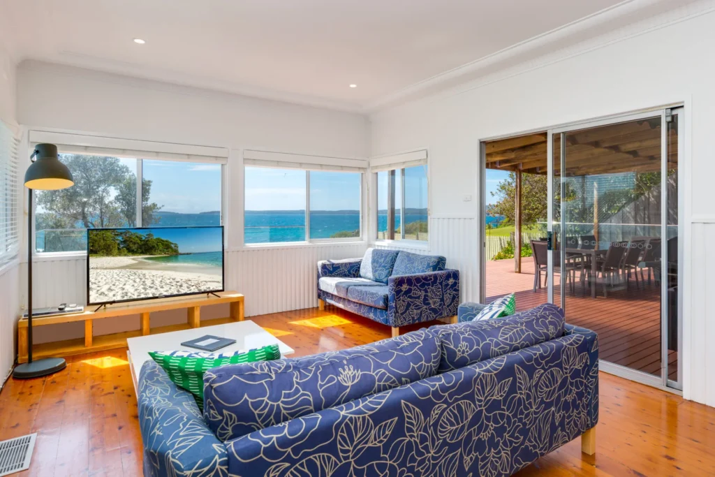Living room at Bimbadgen at Hyams Beach with blue sofas and ocean views