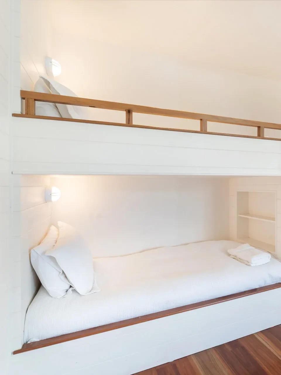 Sleek white bunk beds and timber floors at Coast at Hyams Beach