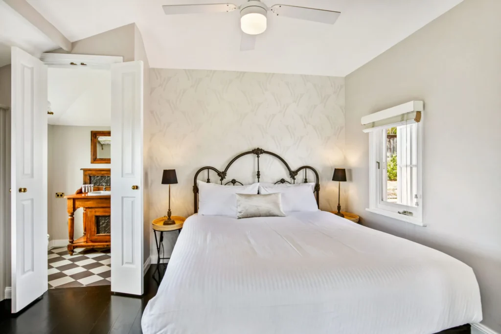 Elegant bedroom with iron bed at Cottage 1 at Hyams Beach