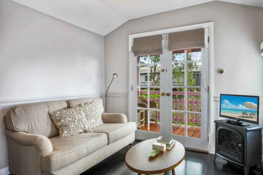 Cozy lounge with sofa and balcony access at Cottage 2 at Hyams Beach