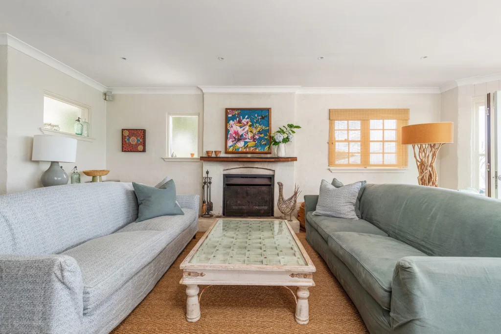 Cozy living room at Elandra, Hyams Beach with sofas and a classic fireplace