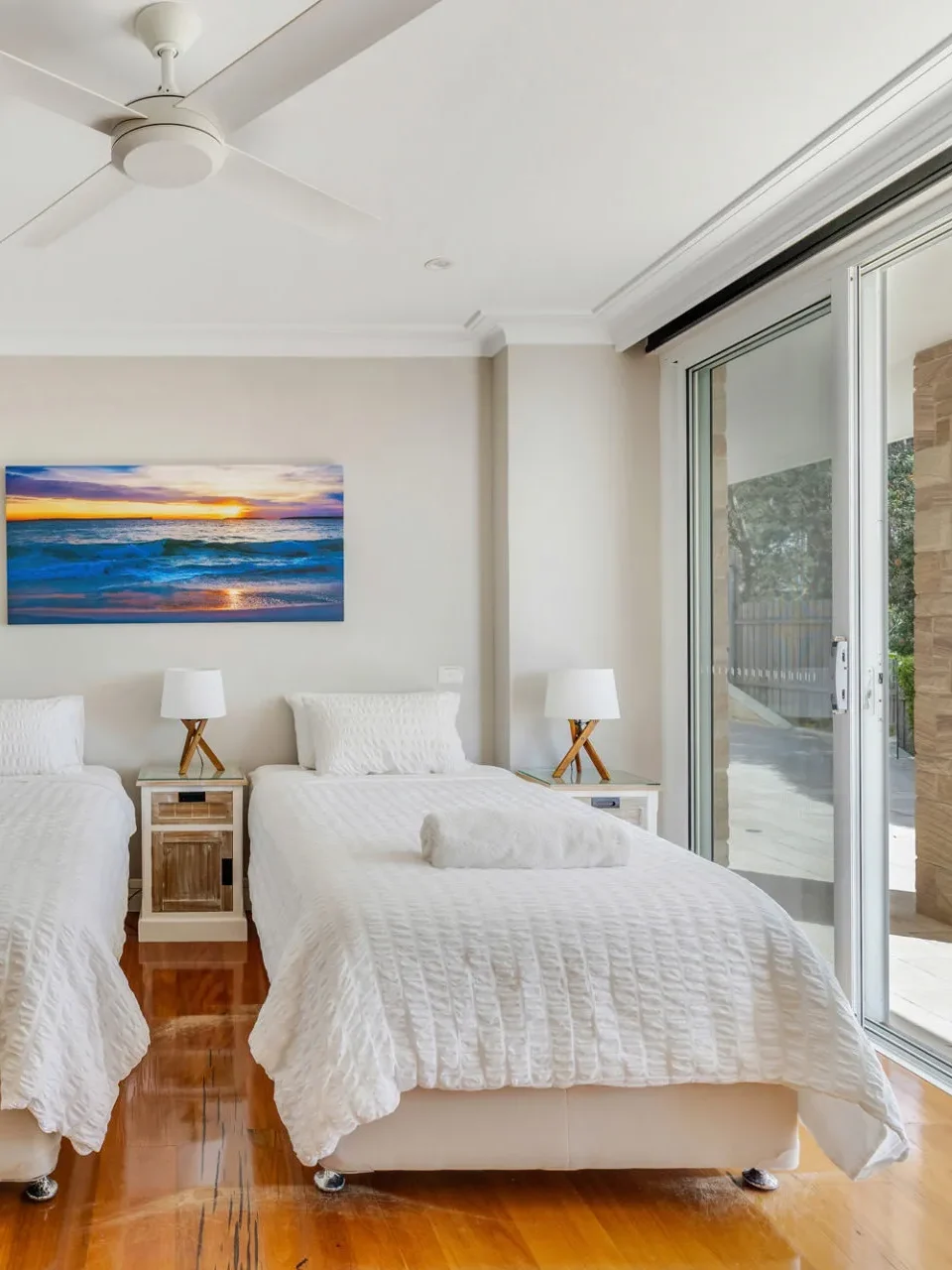 Bright twin bedroom at Horizons at Hyams Beach with ocean-themed art