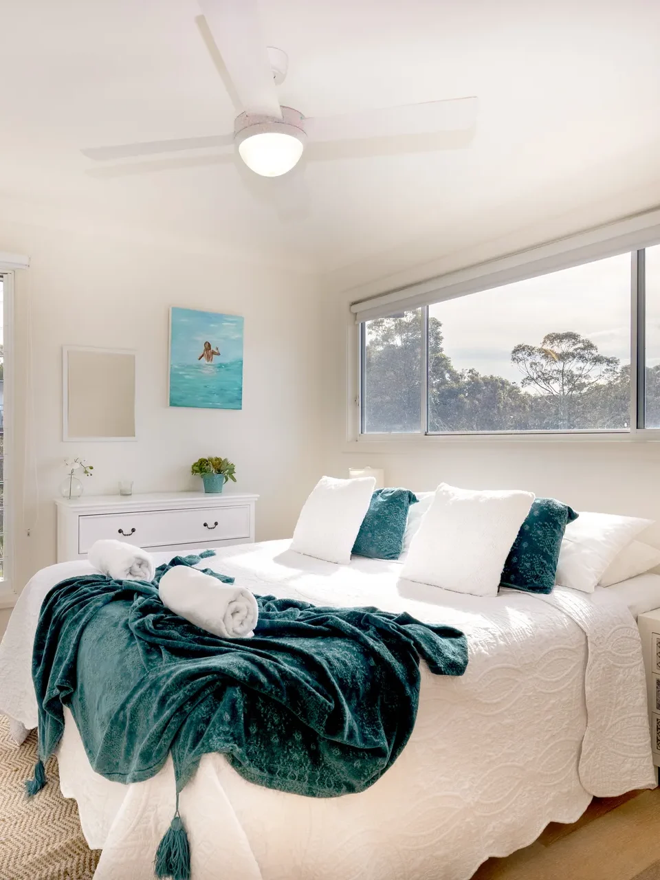 Serene bedroom with teal accents and natural light at Hyamptons Beach House