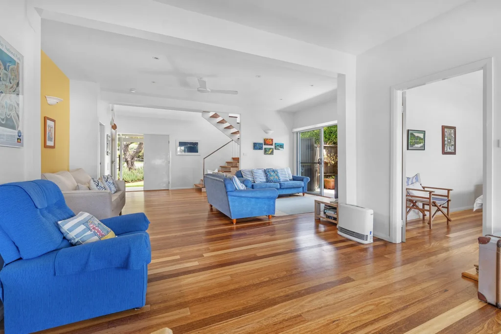Bright family room at Hyams Reflections with blue sofas and timber floors