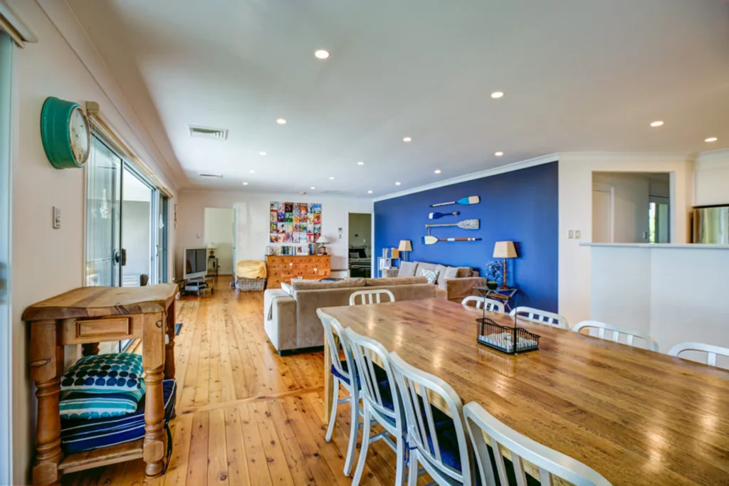 Open living and dining area at Jindalee Beach House with blue wall