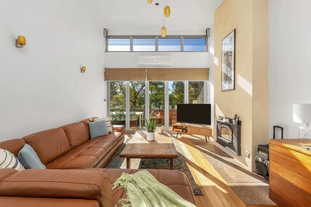 Sun-drenched lounge with leather sofa and fireplace at The Lookout