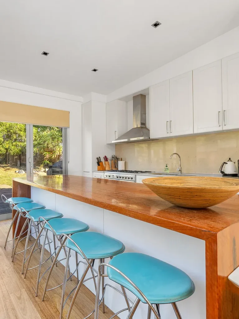Modern kitchen with timber island and blue stools