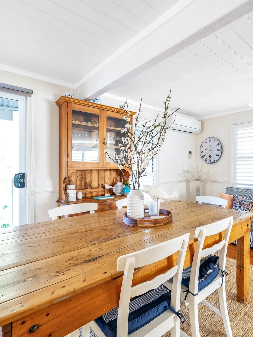 Bright dining area with a rustic wooden table at Mermaid Cottage