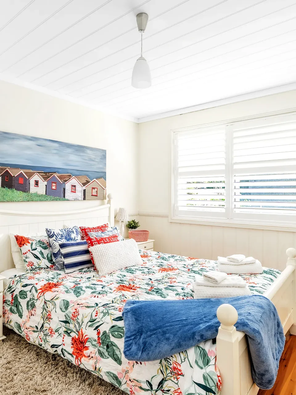 Cozy coastal bedroom with floral bedding at Mermaid Cottage