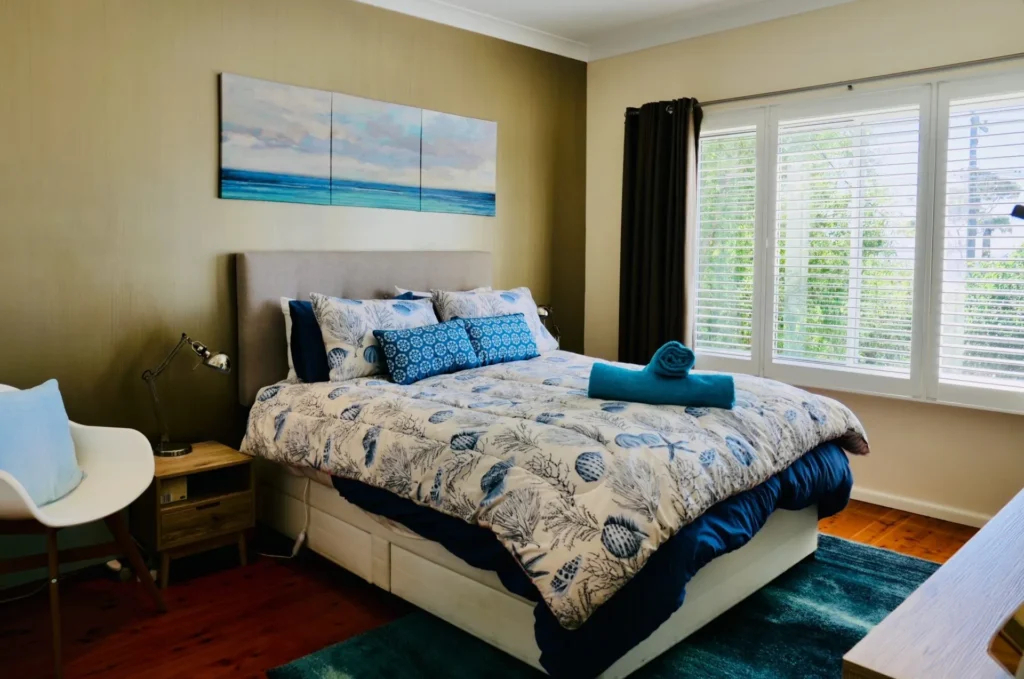 Coastal bedroom with shell-patterned bedding at Nautilus at Hyams Beach