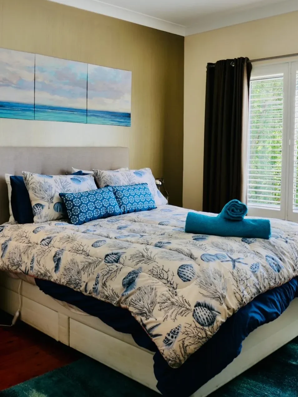 Coastal bedroom with shell-patterned bedding at Nautilus at Hyams Beach