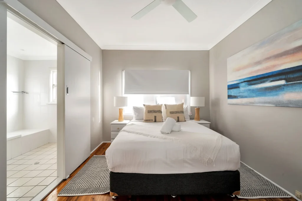Modern bedroom with ensuite and coastal art at Scarborough