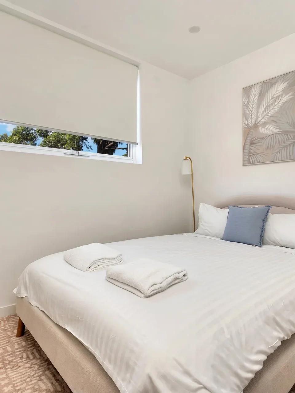 a comfortable bedroom with windows looking at the natural tree settings