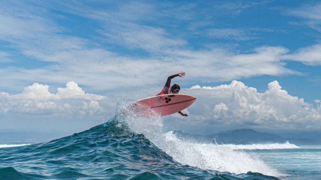 surfer is doing water sport above ocean wave in hyams beach