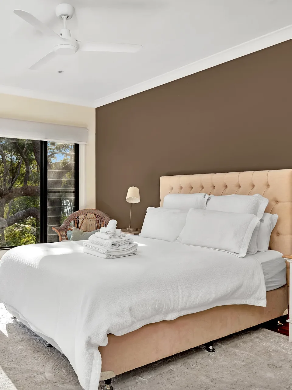 Beige bed and brown wall in Elouera at Greenfields Beach