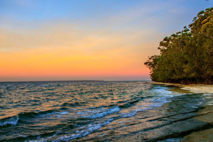 Best time to visit Huskisson for a peaceful sunset walk along the shoreline with calm waves and coastal trees