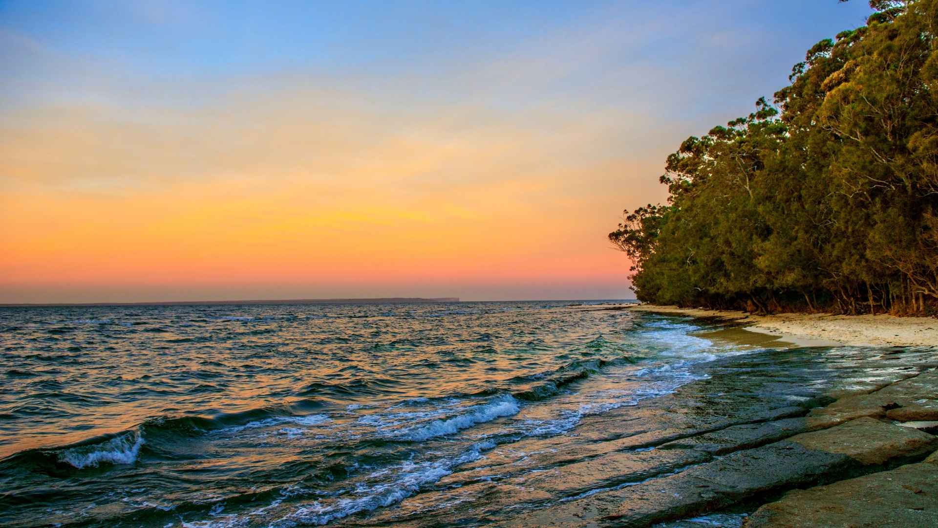Best time to visit Huskisson for a peaceful sunset walk along the shoreline with calm waves and coastal trees