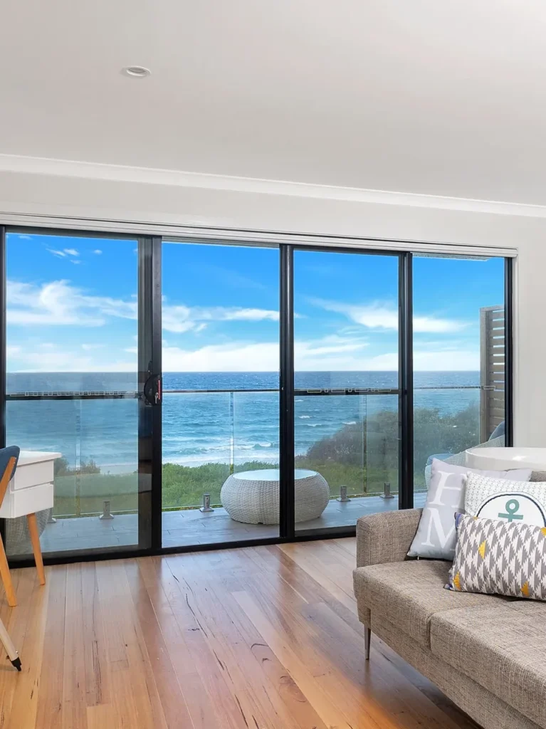 Bright sitting area with a telescope and spa bath at Beach Perfect, Culburra Beach.