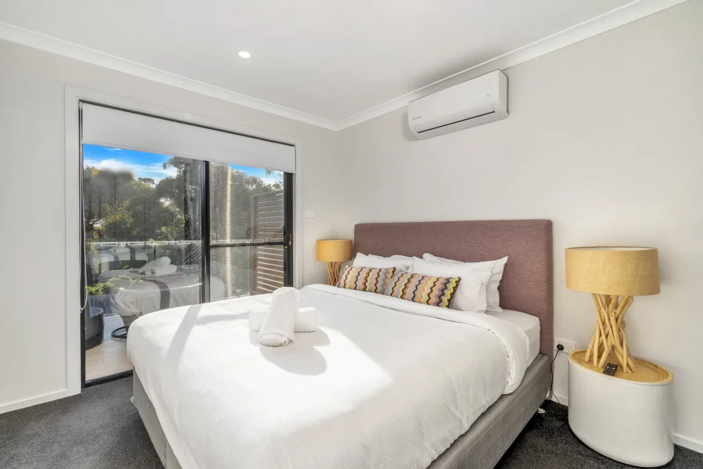 Calm king bedroom with a private balcony at Beach Perfect, Culburra Beach.