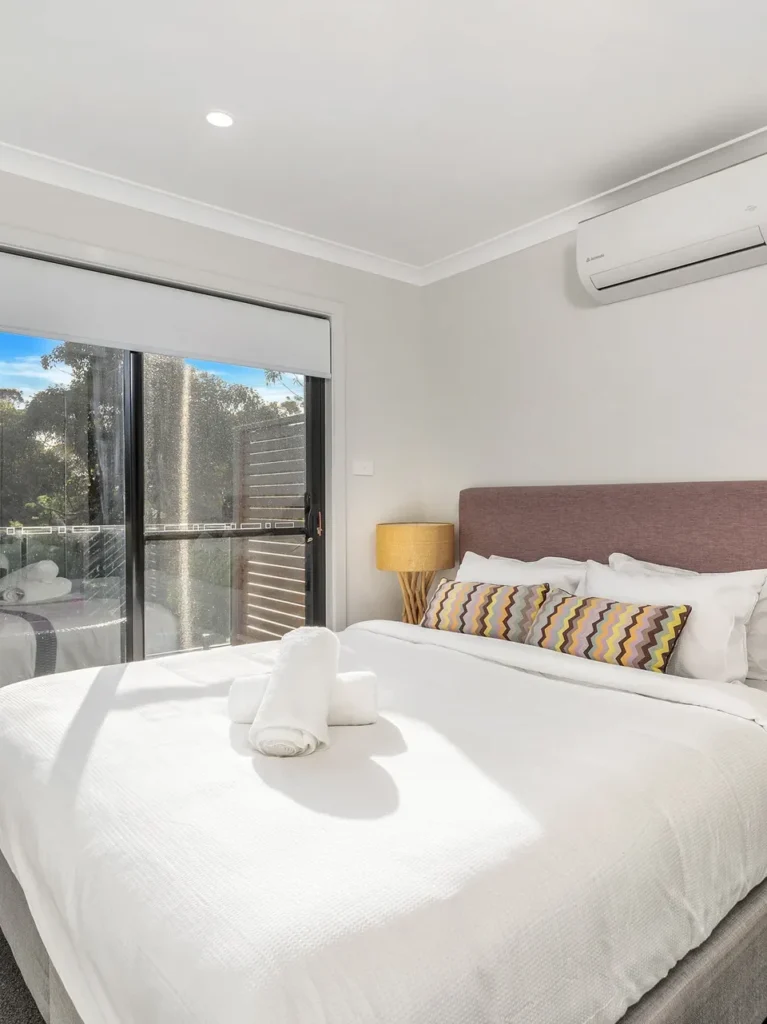 Calm king bedroom with a private balcony at Beach Perfect, Culburra Beach.