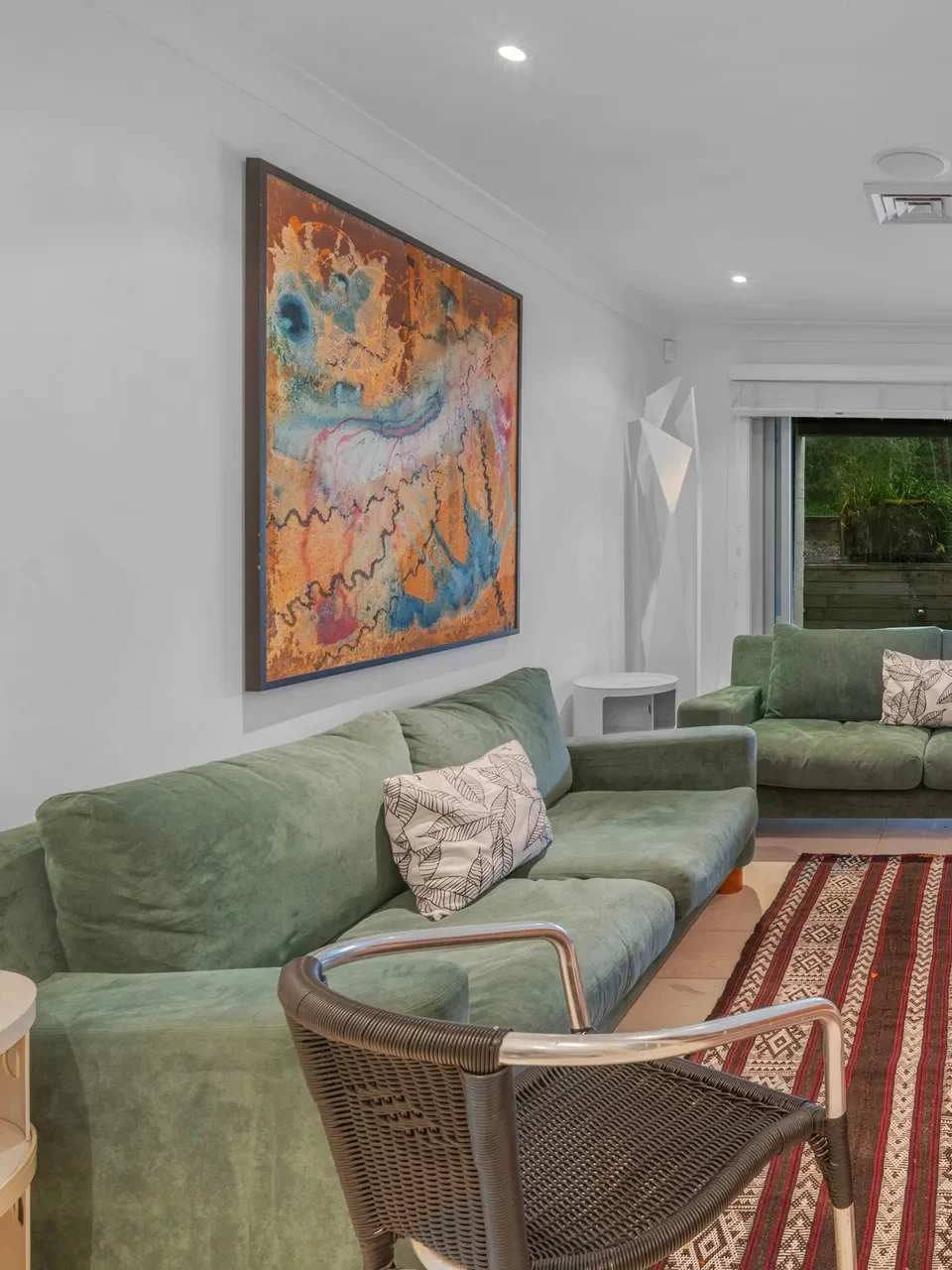 Cosy media lounge with green sofas at Surfbreak, Culburra Beach